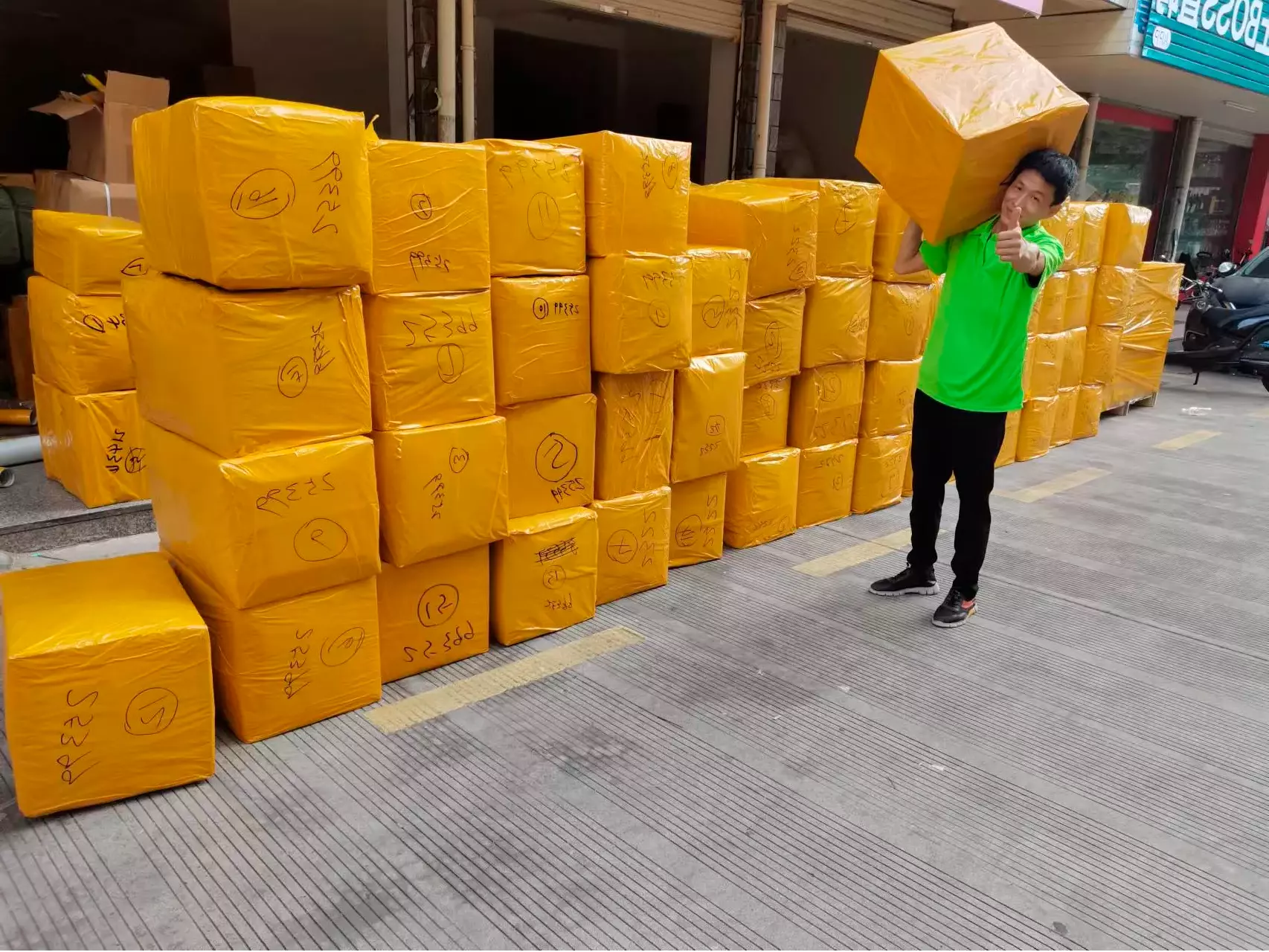 Сотрудник China Towns на складе в Китае с упакованными коробками: каждая обёрнута в мешок и скотч